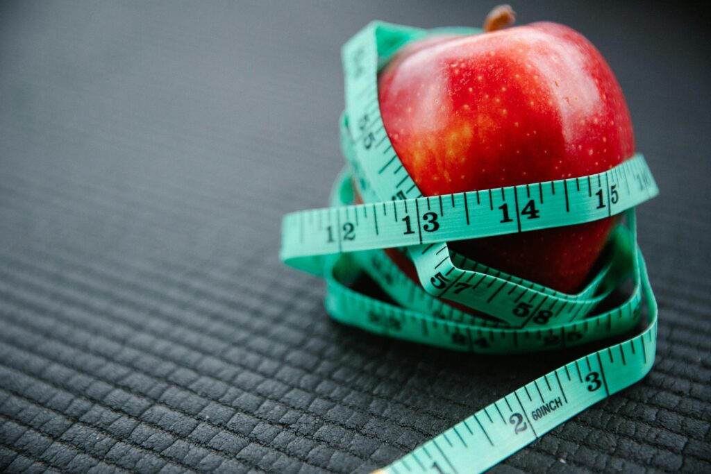An image of an apple with a bodyweight measuring tape wrapped around it.