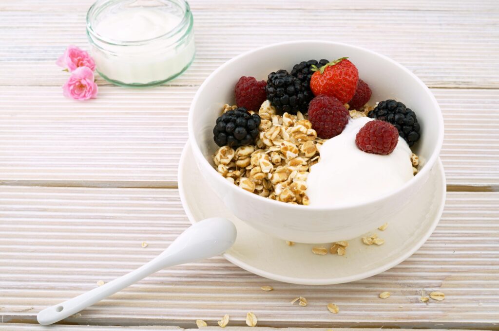 A bowl of Greek yogurt, granola, and a mixture of berries.