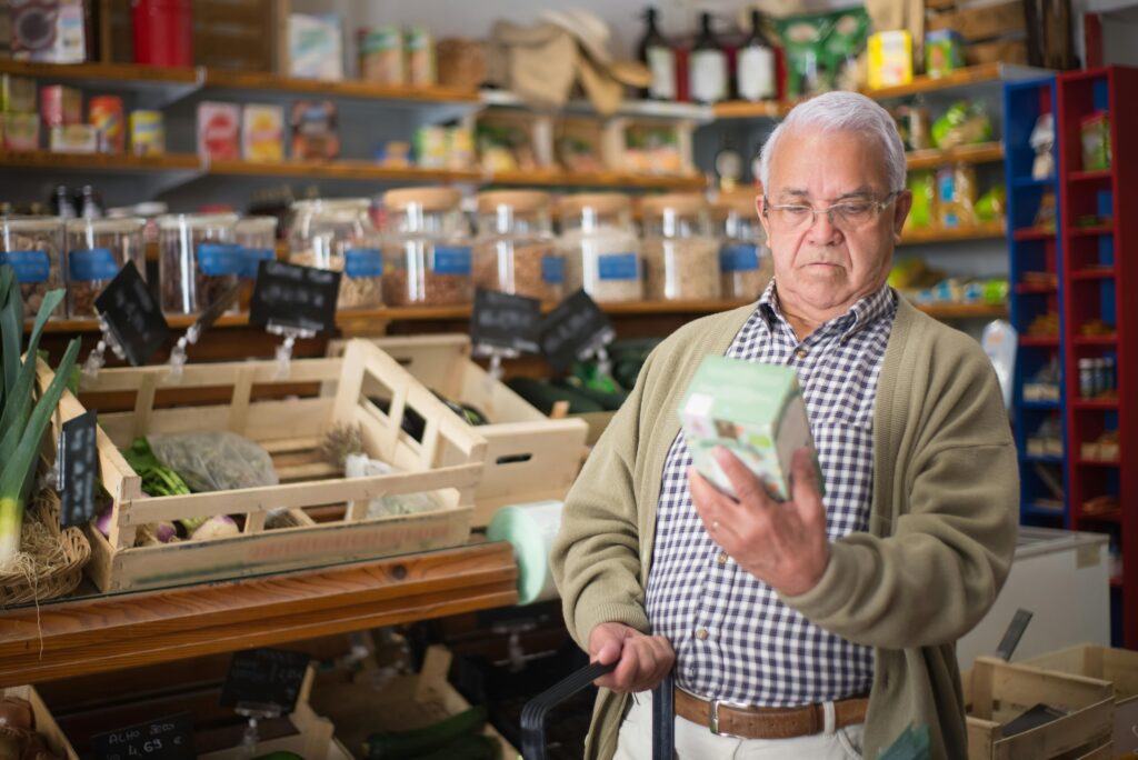An older adult reads the ingredients list to determine if something is vegan.